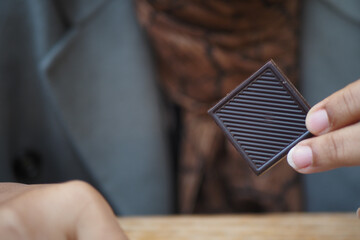 woman holding a dark chocolate candy 