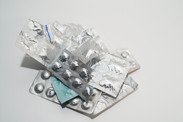 Pile of different medicines group in blister strip packs on white background. Isolated