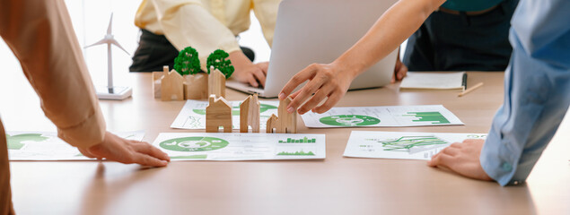 Wooden block represented green city and wind mill represented renewable energy was placed at center...