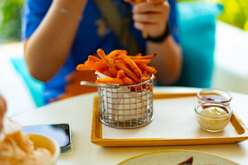 sweet potato fries on table eat by person