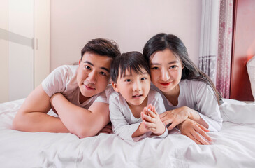 A family of three in the bed in the bedroom