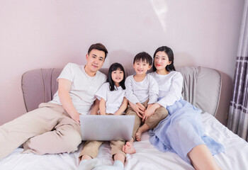 A family of four in bed in the bedroom