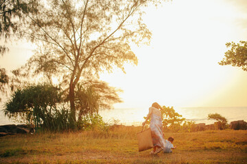 Young mom and her son under the sunset on Phu Quoc island, Vietnam