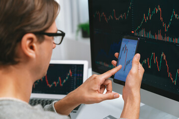 Smart stock investors pointing on screen with smartphone for market stock exchange along with...