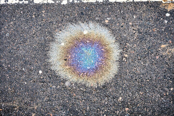 Spills of fuel or oil on the asphalt road as texture or background