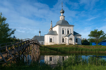 View of the Church of the Epiphany (Epiphany Church) in Kozhevennaya Sloboda and the bridge over the Kamenka River on a sunny summer day, Suzdal, Vladimir region, Russia