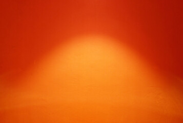 Spotlight on the surface of orange painting concrete wall background.