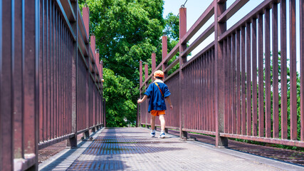 歩道橋を歩く保育園の園児、後ろ姿
