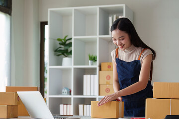 Woman entrepreneur working at home office and taking a parcel photo before delivery