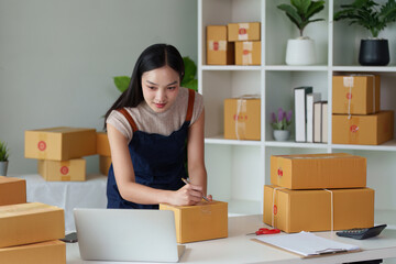 Woman entrepreneur working at home office and taking a parcel photo before delivery