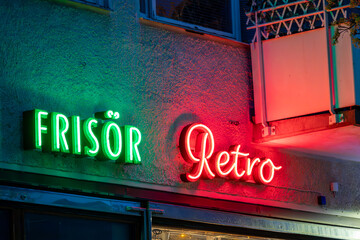Stockholm, Sweden  A red and green neon sign in the Hokarangen suburb say in Swedish ,Hair salon...