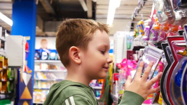 Close-up of a happy smiling boy taking a toy in a toy shop