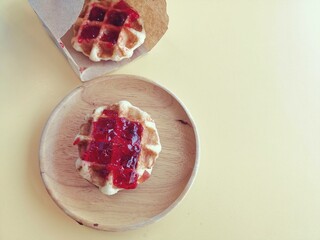 Breakfast of waffle with strawberry jam