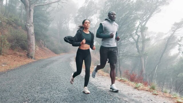 Healthy, running and couple with fitness, exercise and rain with wellness and training with endurance. Cardio, outdoor and wet road with man and woman with a hobby and runner with sports and progress