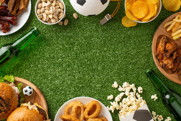 Perfect setting for a football game day with assorted snacks and drinks arranged on a green...