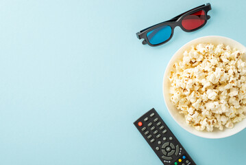 Home theater setup with snacks: Overhead shot of savory popcorn, 3D glasses, and streaming remote....
