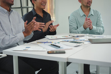 Happy team of young Asian businessmen Clap your hands together and celebrate your successful start-up. Brainstorming meeting of creative team, partners, teamwork concept in office.