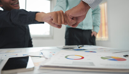 A team of businessmen clenching their fists together agrees to work as a team to work together on finance. Investment in real estate projects, meetings, summaries of internal office management.