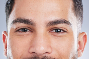 Happy man, portrait and eyes with natural skin for grooming, eyebrows or masculine beauty on a gray...
