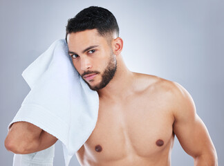 Man, towel and cleaning face in studio portrait for health, shine and hygiene by background....