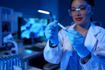 A research scientist or doctor is viewing and storing a sample of a substance for research with...