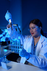 Scientist working in laboratory using micropipette Mixing liquid chemicals with genetically...