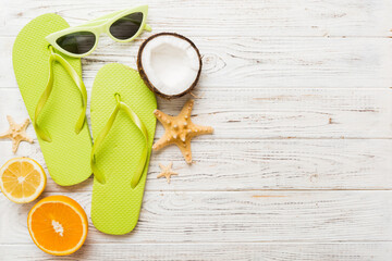 Top view composition of flip flops placed with beach accessories top view on table background....