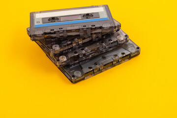 Retro audio cassette tape from the 80s on a yellow background.