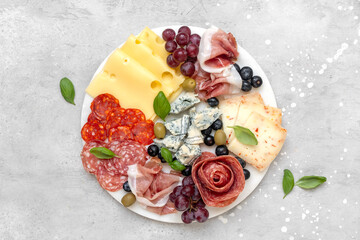 Italian food antipasto prosciutto ham, salami, olives and grissini breadsticks. cheese plate parmesan, pecorino, gorgonzola. Charcuterie board. elegant serving, banquet cold meat plate