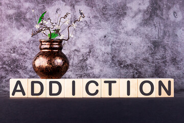 ADDICTION word made with building blocks on a grey background.