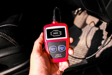 OBD scanner tool , OBD2 scanner in a car mechanic hand for car engine system analysis , Car maintenance and servicing concept