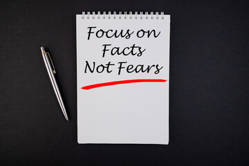 Focus on Facts Not Fears notepad writing concept on dark background with pen