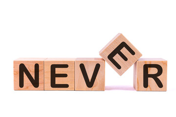 Never word concept written on wooden cubes on a white background