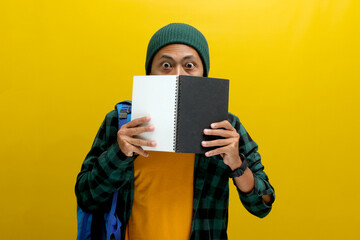Shocked Asian male student, wearing a beanie and casual clothes and carrying a backpack, is seen...