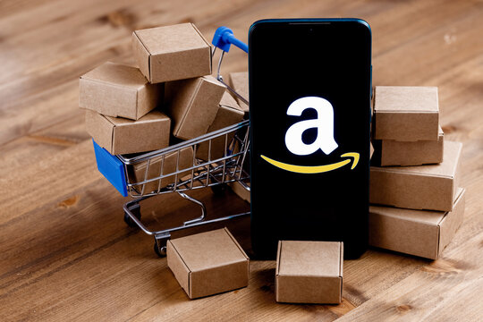 Kazan, Russia - Oct 02, 2021: Amazon is an American company, one of the world's largest e-commerce platform markets. Smartphone with Amazon logo on the screen, shopping cart and parcels.