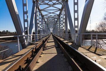 Railway bridge over the river. Spring landscape in the background.