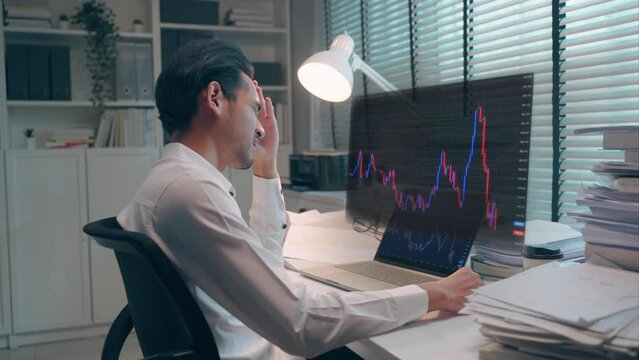 Frustrated Asian broker trader man frustrated in investing stock market.	
