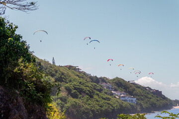 Colorful Paragliders Flying Above the Cliffside Coast of Bali