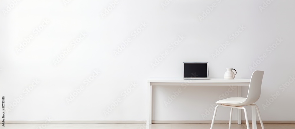 Poster A white table with a chair and a laptop creating a minimalist setting with copy space image