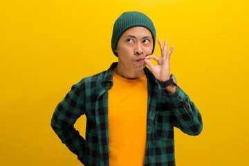 Young Asian man, dressed in a beanie hat and casual shirt, zips his lips in a promise to keep a...