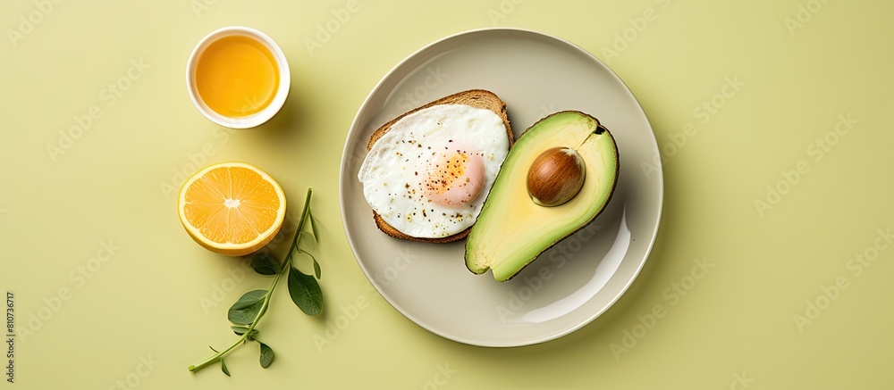 Poster A healthy breakfast featuring avocado egg and toast is presented on a yellow background The top down view allows for a copy space image