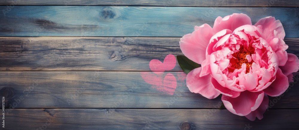 Sticker Top view of an old grunge painted board with a pink peony and a heart carved in wood creating a stylish copy space image