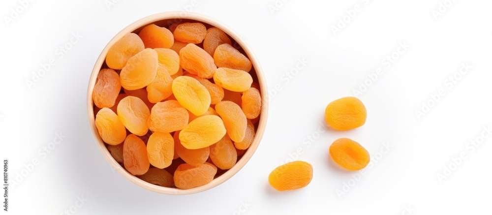Poster copy space image of a top view bowl filled with dried apricots on a white background offering a heal