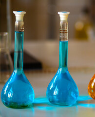 Flasks and test tubes with multi-colored chemical liquids in a laboratory in a clinic. Testing, analysis and research in laboratories. Clinical study.
