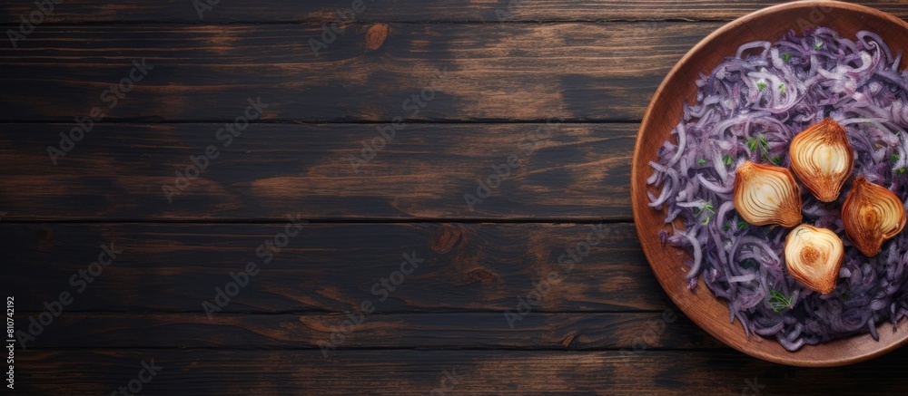 Poster A top view close up of a plate on a wooden table with a copy space image of fried blue cabbage onion apple and garlic