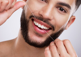 Portrait, man and teeth with floss in studio for mouth care, oral hygiene and fresh breath. Morning routine, male person and smile with dental product for cavity prevention, protection and gum health