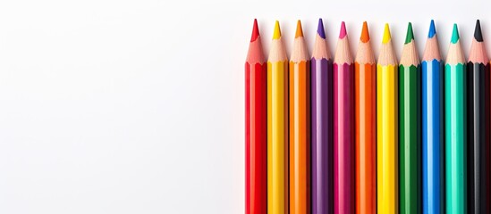 Fototapeta premium From an overhead perspective a close up image captures a collection of color pencils situated on a white background with ample space for text