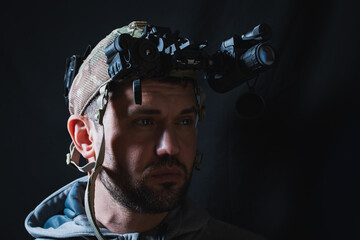 A military man with night vision device on his head. Portrait photo.