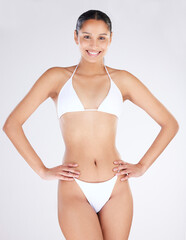 Fototapeta premium Woman, confidence and portrait in studio with bikini for summer, tropical and beach body. Female model, happy and smile in swimsuit for vacation or holiday on white background with mockup space