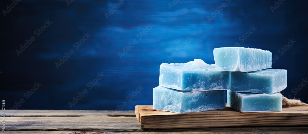 Poster Handcrafted soap displayed on a rustic blue wooden table creating a visually appealing copy space image